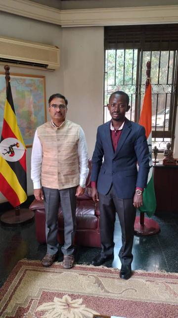 Two guests in an office with the flags of Uganda and India