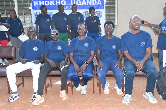 The course team seated in front of the banner