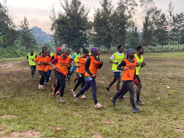 Participants in orange and green bibs on the field