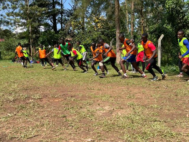 Participants in bibs run a drill