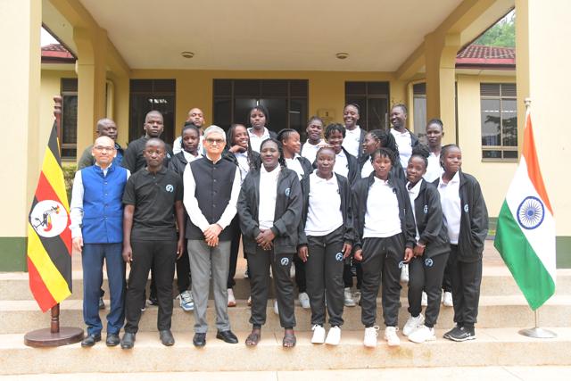 The team and officials with the flags of Uganda and India