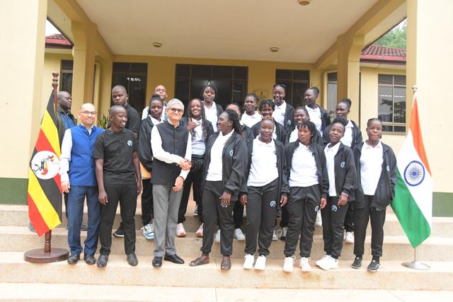 The team and officials with the flags of Uganda and India