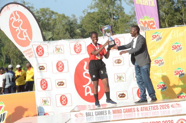 A trophy is presented to a player in red kit